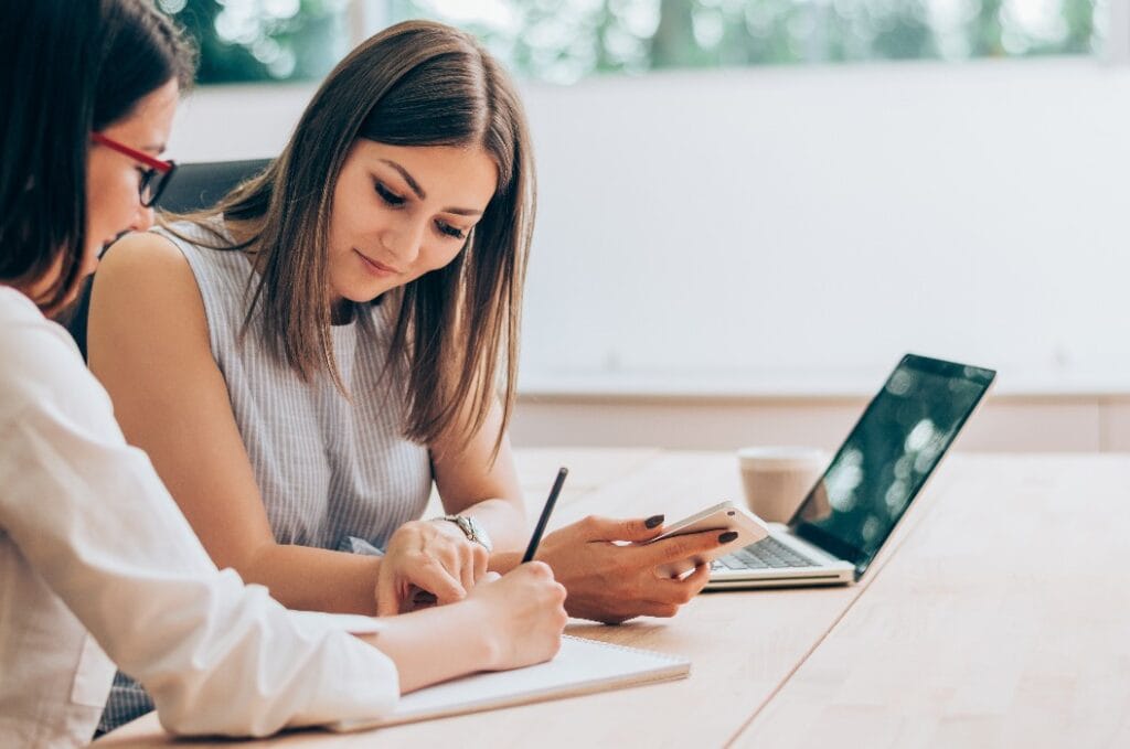 Two female colleagues in office working together.